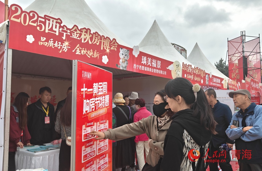 市民在房企展位前咨询。