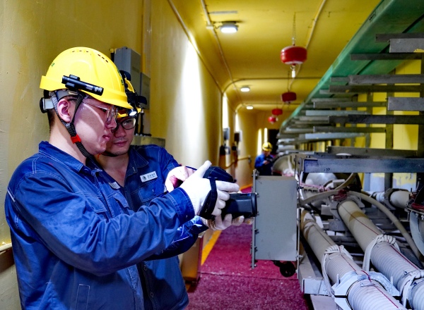 巡检人员使用智能设备进行电缆通道特巡工作。